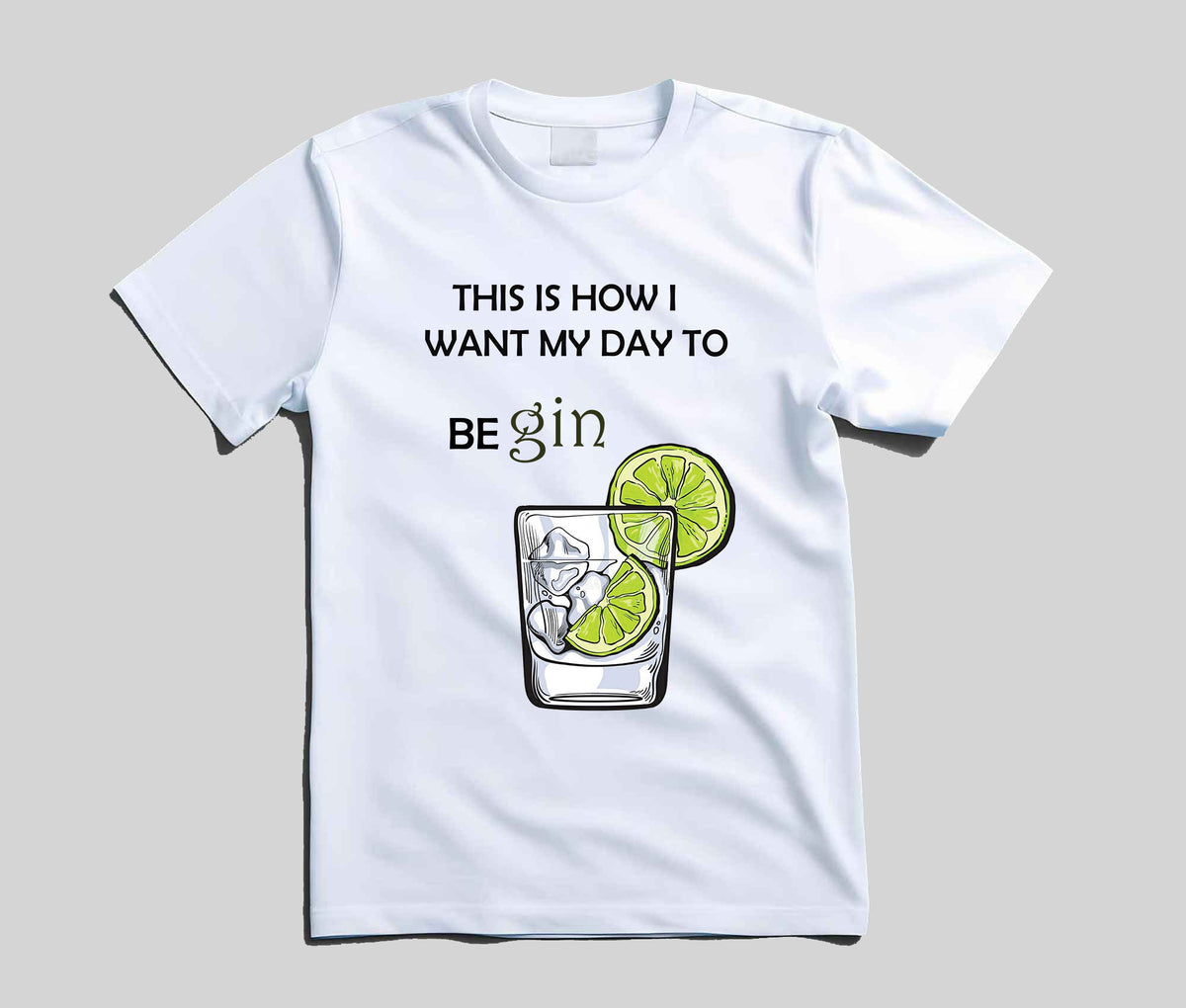 A white short-sleeve t-shirt with a graphic print that reads 'THIS IS HOW I WANT MY DAY TO BE gin' above an illustration of a gin glass with lime slices, shown on a neutral gray background.